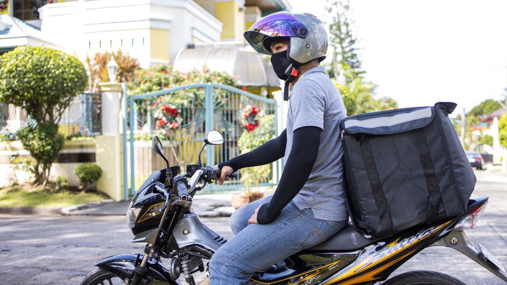 A Rokomari delivery man is delivering books to a customer, showcasing the process of online book order fulfillment.